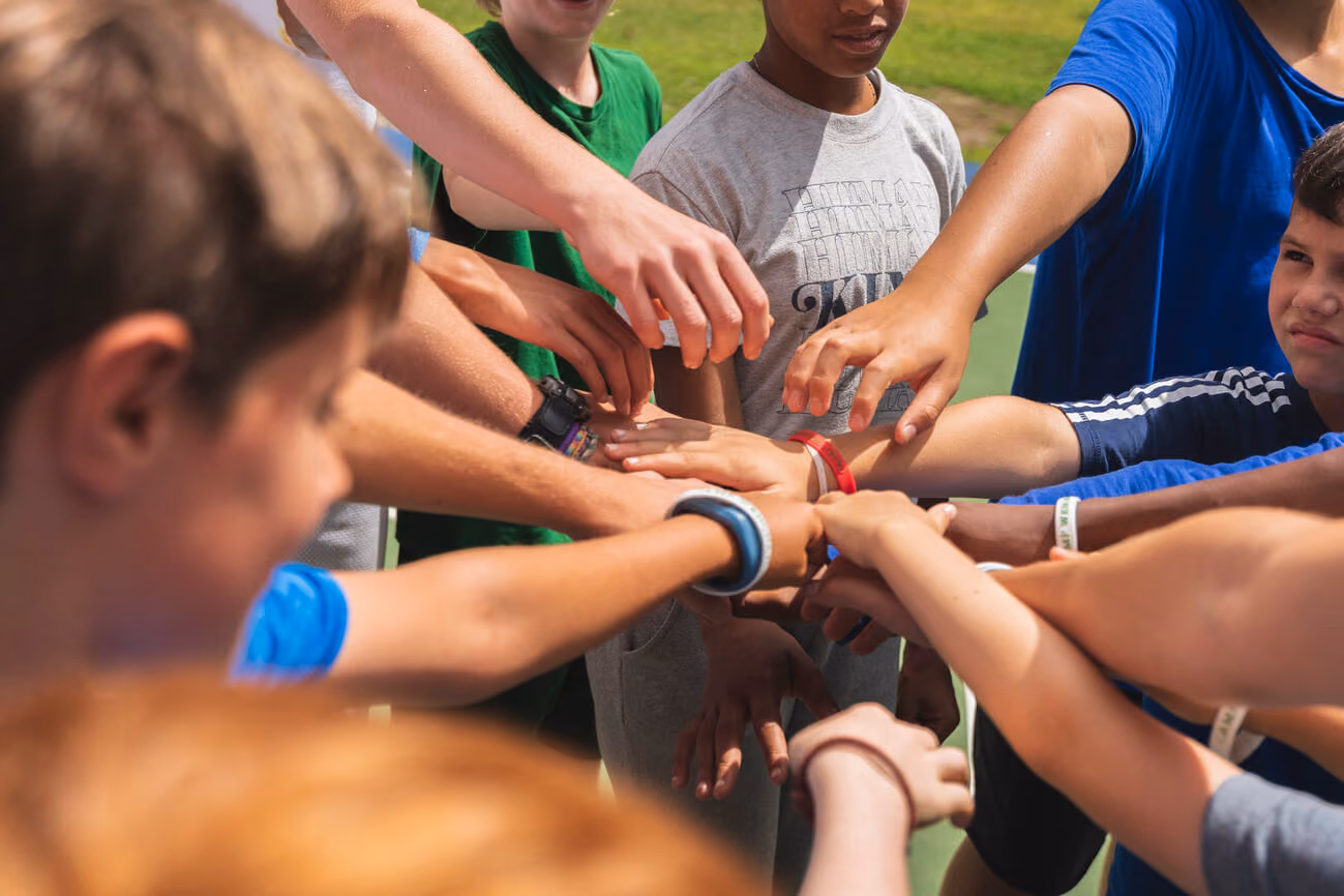 Campers at summer camp joining their hands together